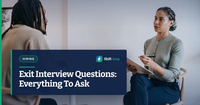 Focused ethnic female interviewer or psychotherapist asking questions and writing notes in clipboard while looking at African American male